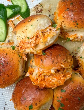 Spicy Buffalo Chicken Sliders served on a platter with melted cheese and Buffalo sauce drizzle.
