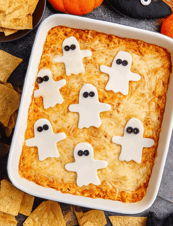 Halloween Buffalo Chicken Dip with spiderweb sour cream design served in pumpkin bowl