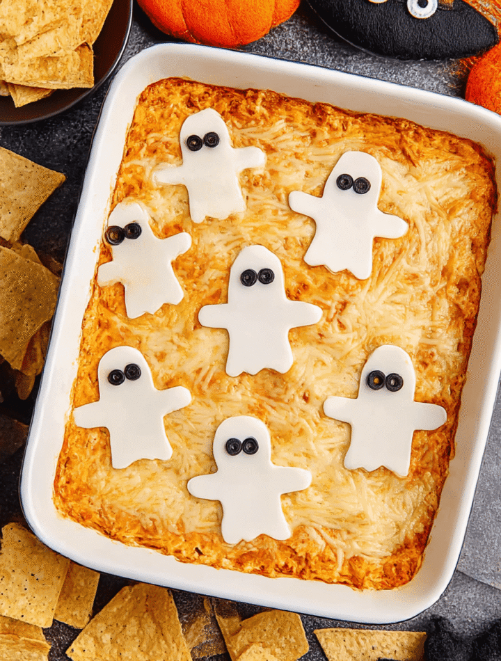Halloween Buffalo Chicken Dip with spiderweb sour cream design served in pumpkin bowl